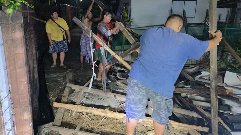 View full size Neighbours dig out a 70-year-old man after his old wooden house collapses
